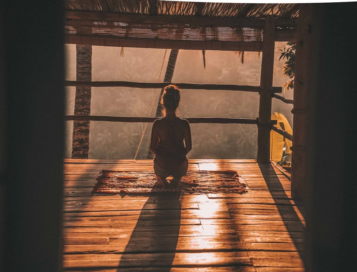 Mulher em meditação com vista sobre as árvores
