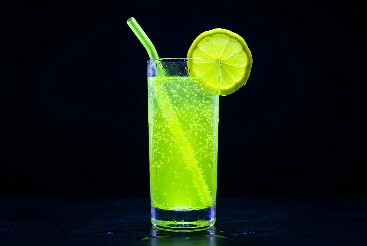 Glowing neon green Charged Lemonade in a highball glass with lime wheel