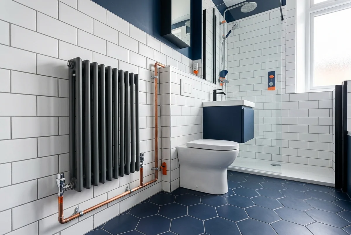 Newly installed bathroom with radiator and central-heating pipework