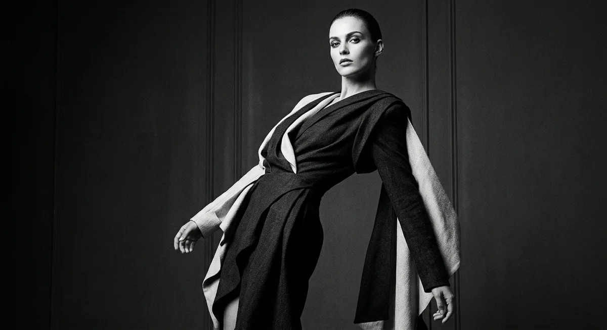 Avant-garde fashion model in a sculptural black-and-white couture ensemble, shot in dramatic studio light